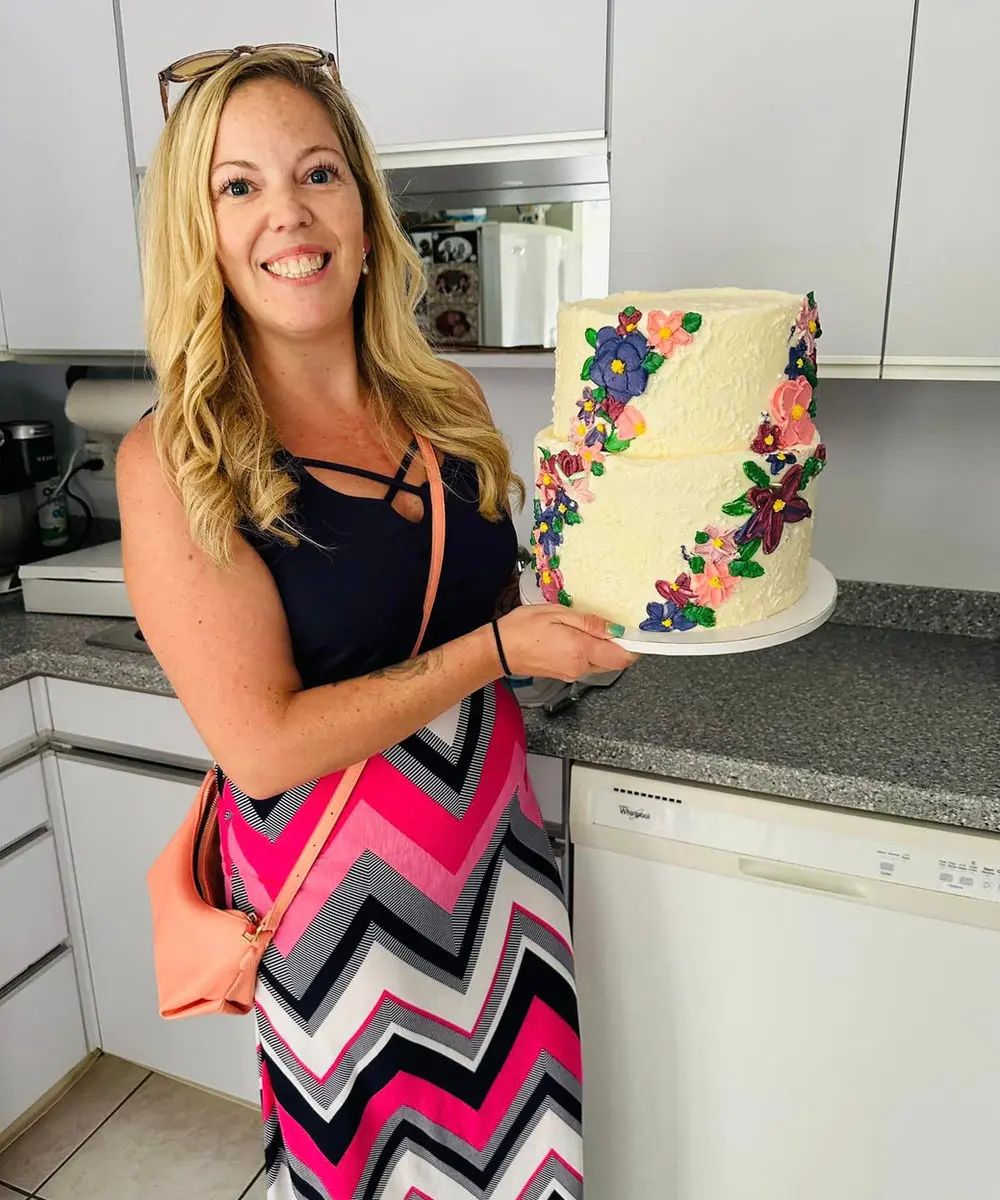 Heather, founder of Frontline Cafe & Bakery, holding one of her custom cakes