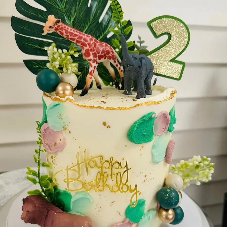 Safari-themed cake with giraffe and elephant figurines